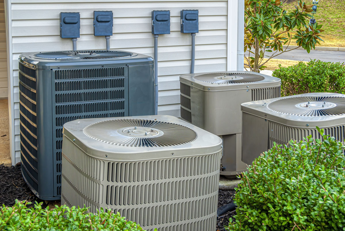 HVAC units on the side of a multifamily buiding
